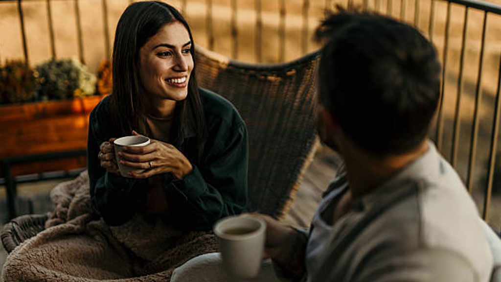 Couple profitant d'un café sur le balcon de leur logement flexible près de Genève